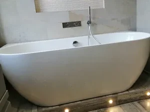 Modern freestanding bathtub in a stylish bathroom with ambient lighting.